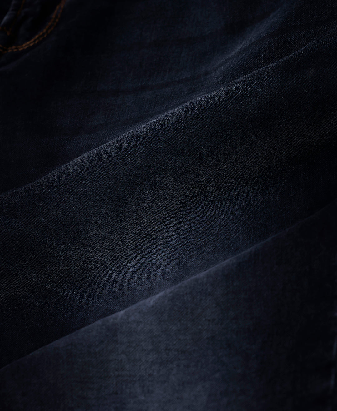 Woman wearing a red natural fade wash red cast denim on a light gray background