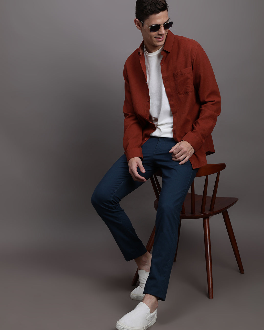 Man wearing a navy solid slim fit casual navy trouser on a light gray background