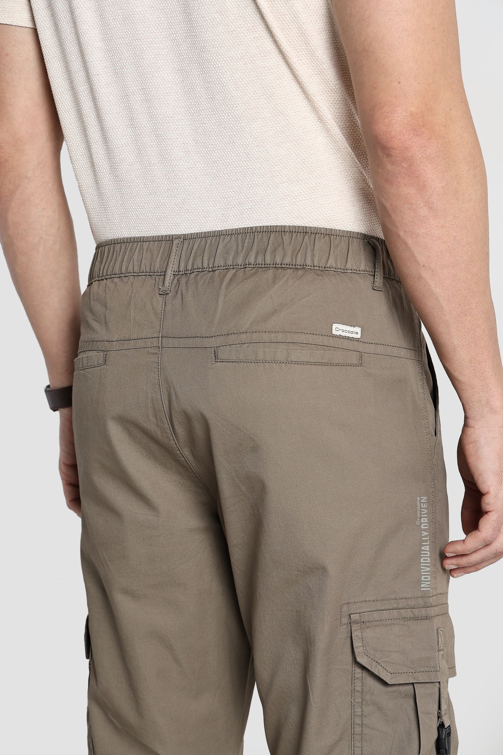 Person wearing brown cargo pants on a white background