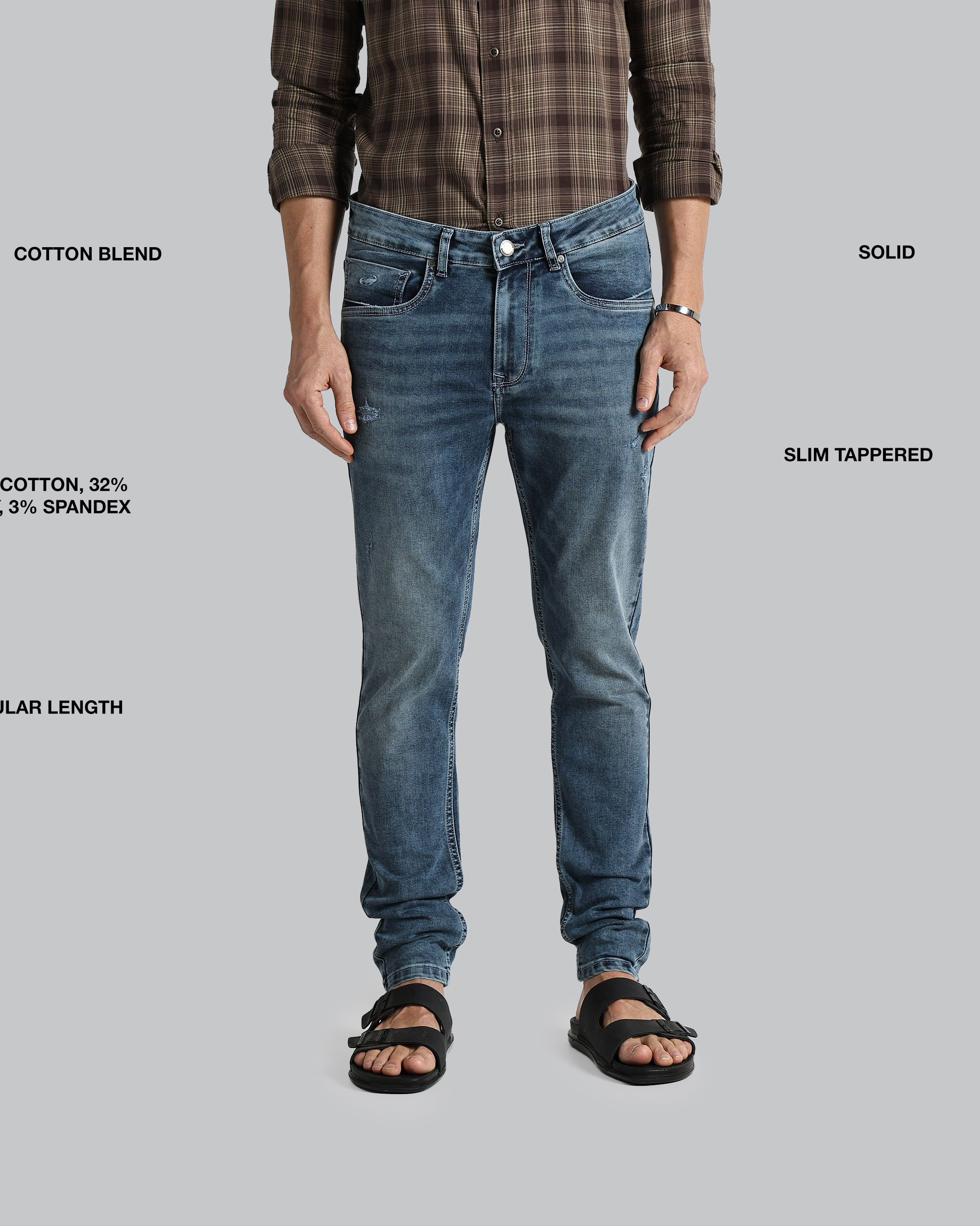 Person wearing blue jeans with text detailing fabric blend, length, and style on a gray background