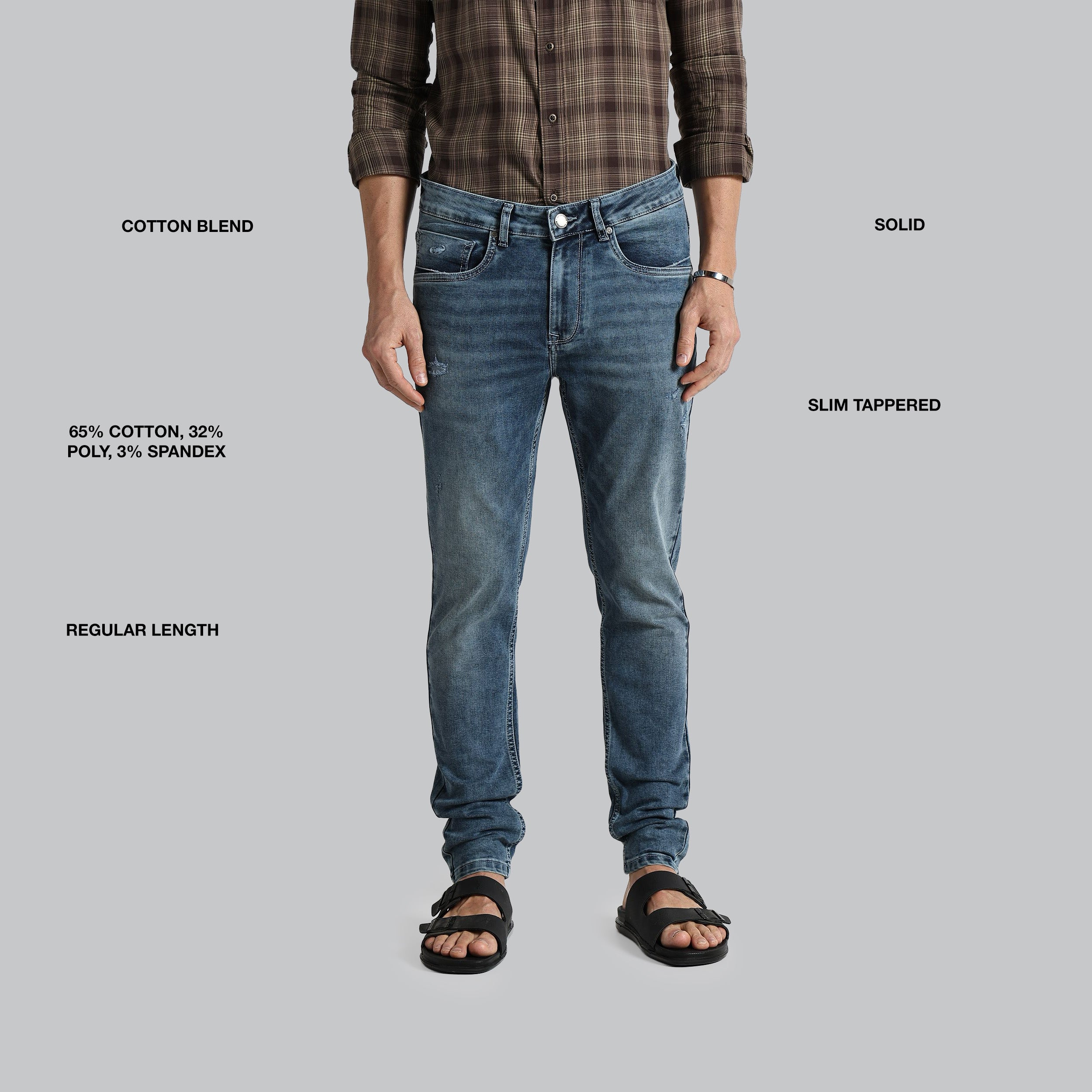 Person wearing blue jeans with text detailing fabric blend, length, and style on a gray background