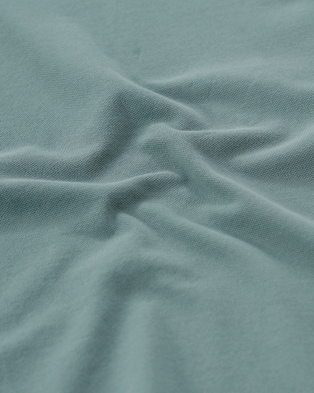 Man wearing a green iceberg green chest print slim fit polo t shirt on a light gray background