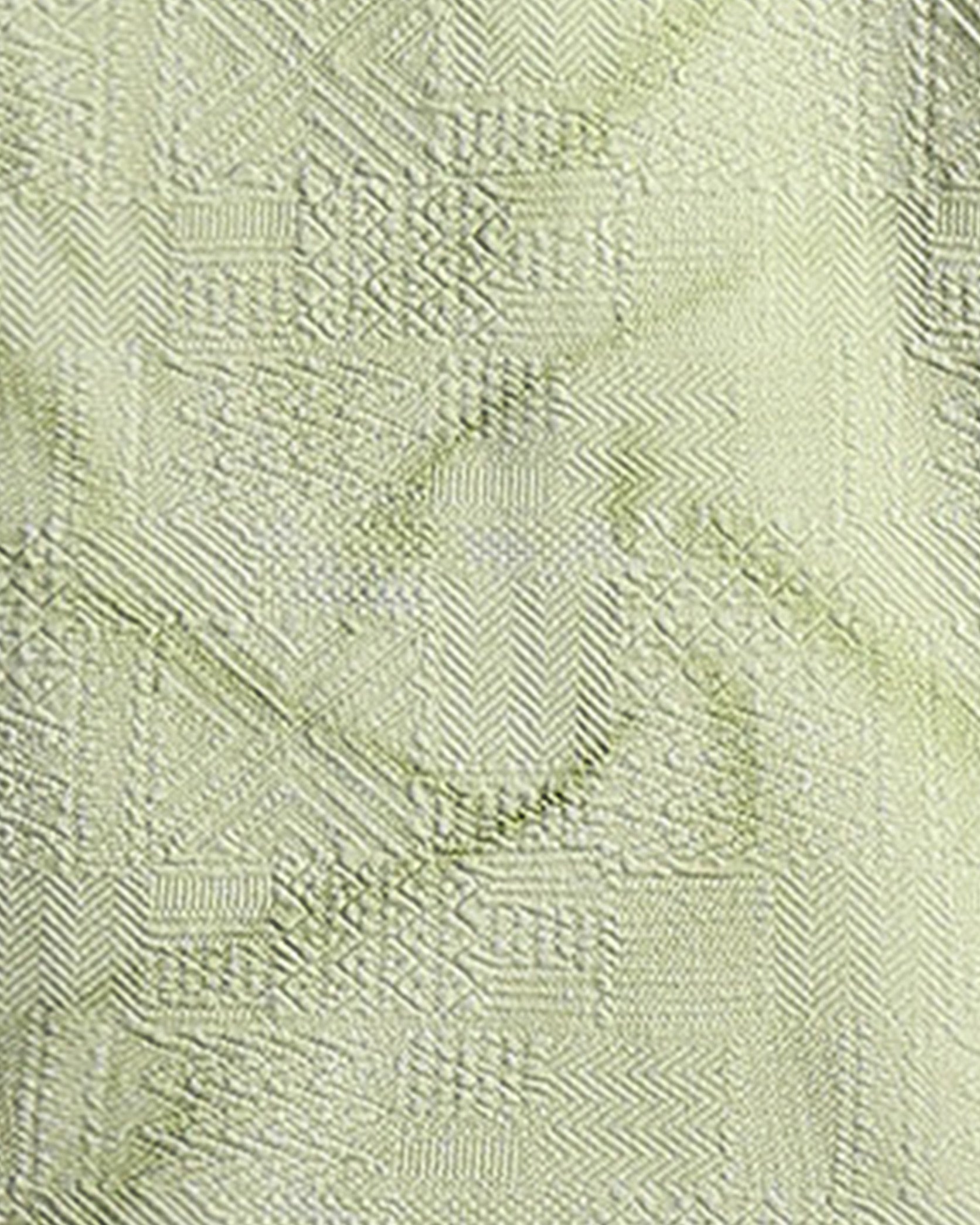 Close-up of a textured light green fabric with a subtle pattern
