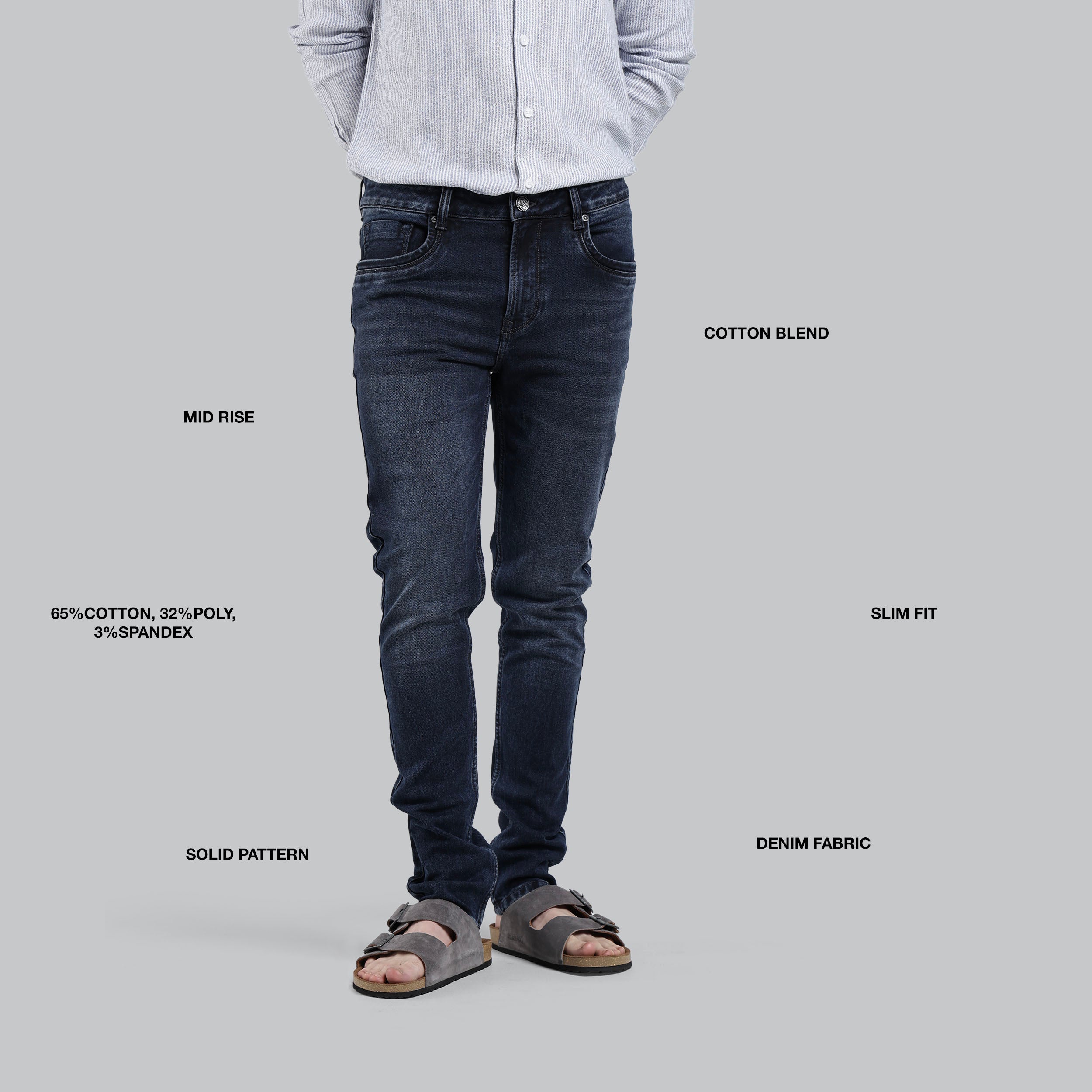 Person wearing dark jeans with fabric and fit details on a gray background