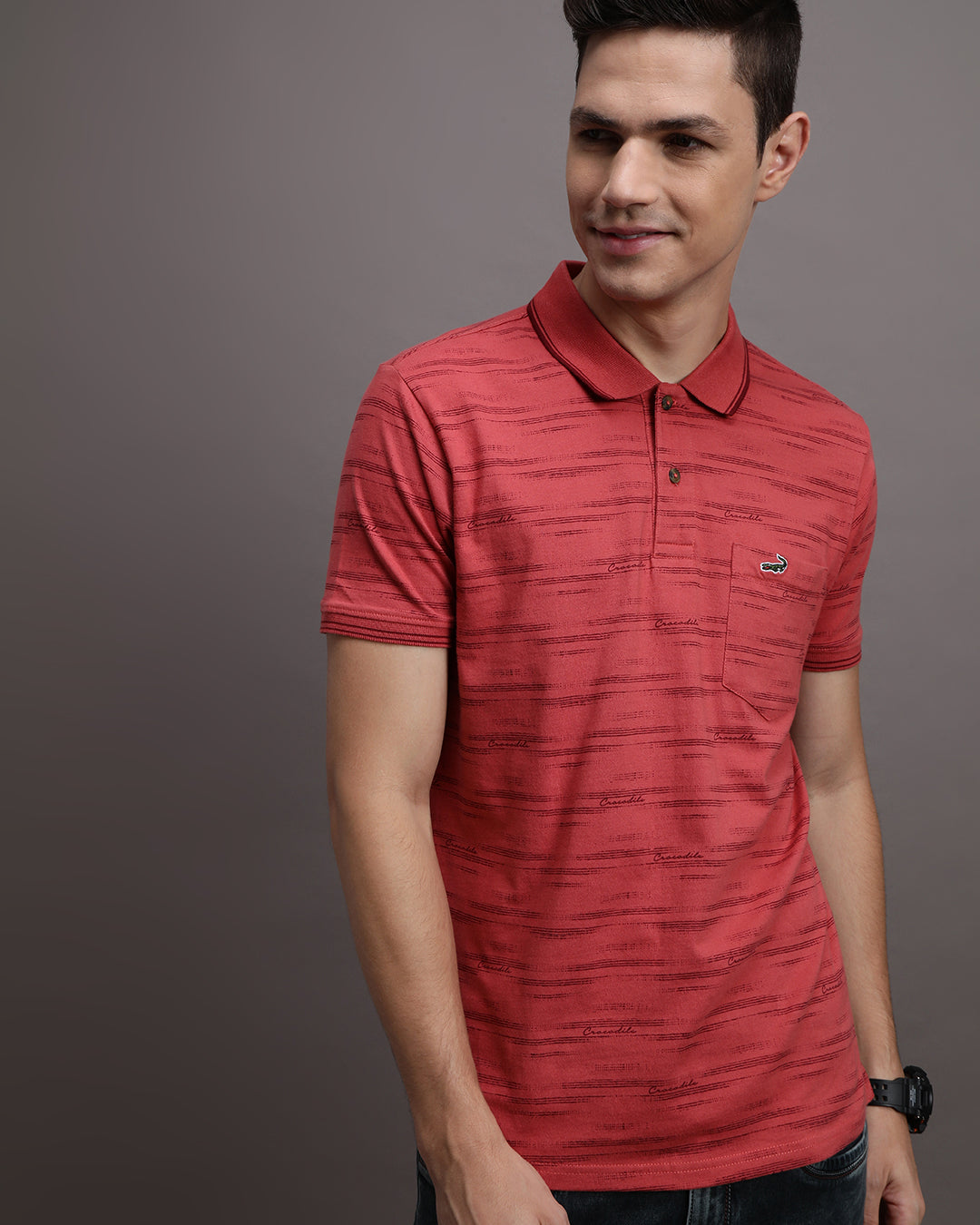 Man wearing a red mineral red printed casual polo t shirt with casual styling on a gray background
