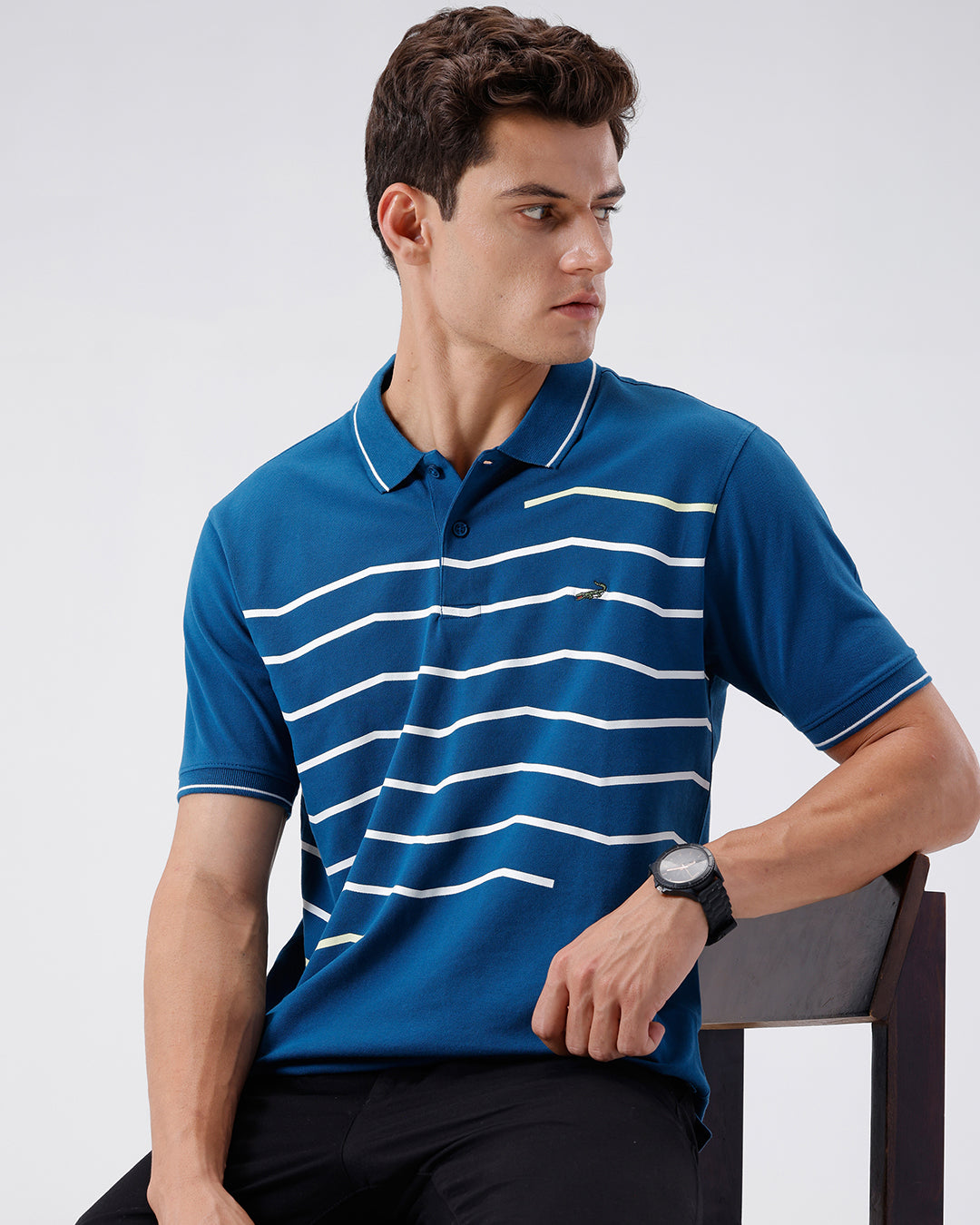 Man wearing a green iceberg green chest print slim fit polo t shirt on a light gray background