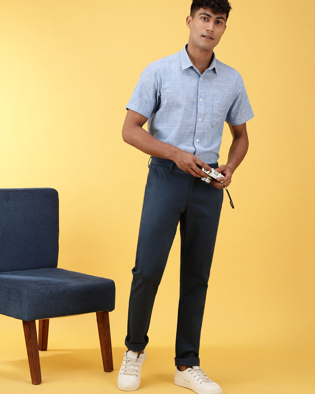 Man wearing a navy solid slim fit casual trouser navy on a light gray background