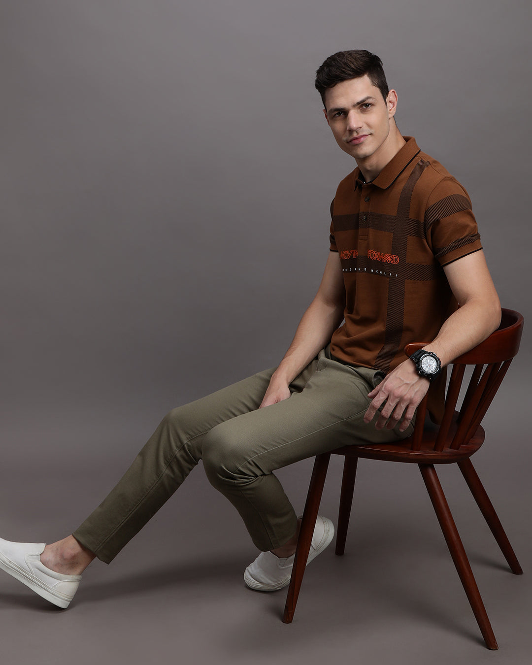 Man wearing a yellow rubber yellow printed polo t shirt with casual styling on a gray background