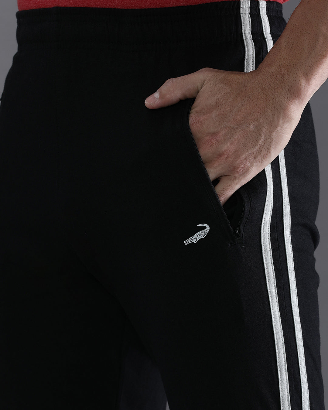 Black tracksuit with white stripes and a logo on a dark background