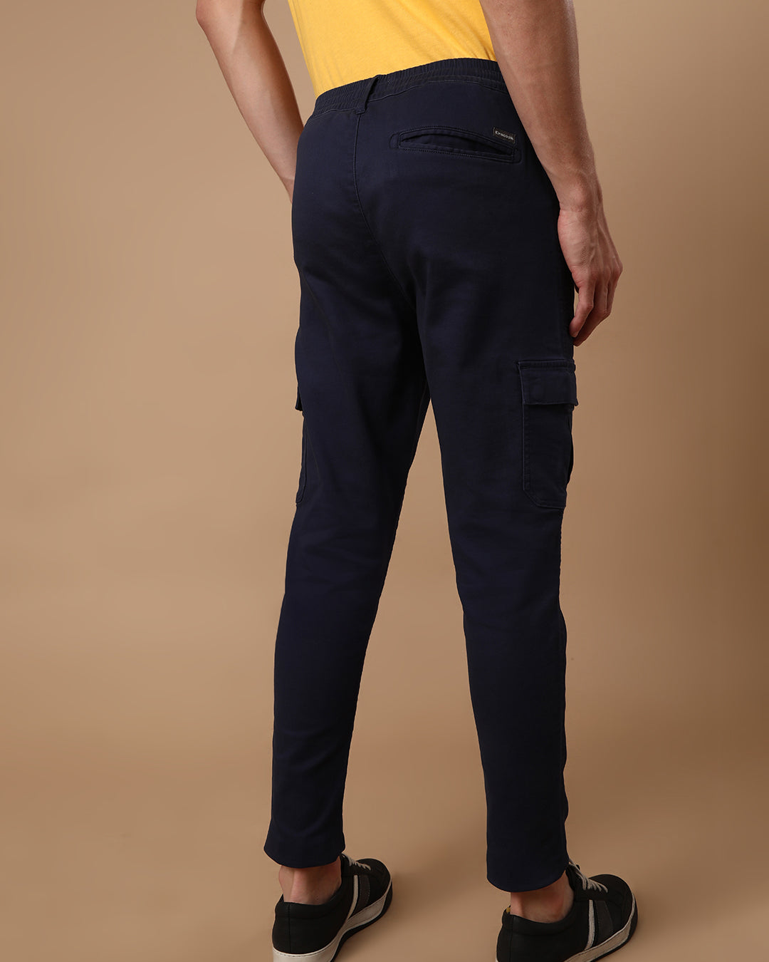 Man wearing a navy super soft navy cargo jogger with casual styling on a gray background