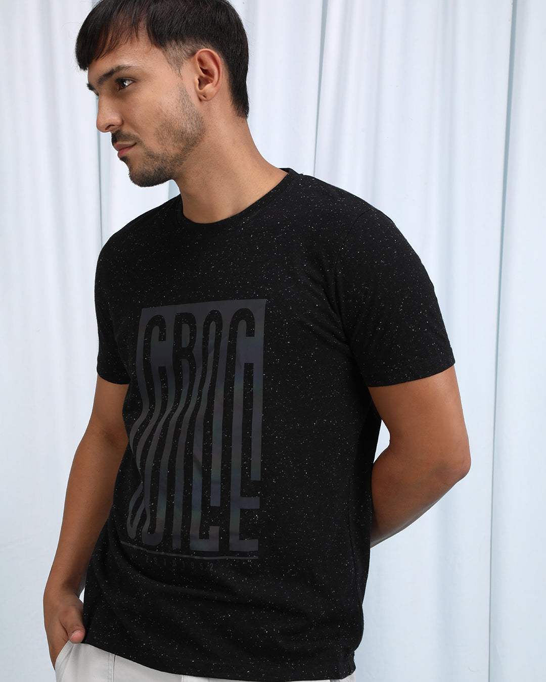 Man wearing a brown brown casual printed t shirt with casual styling on a gray background