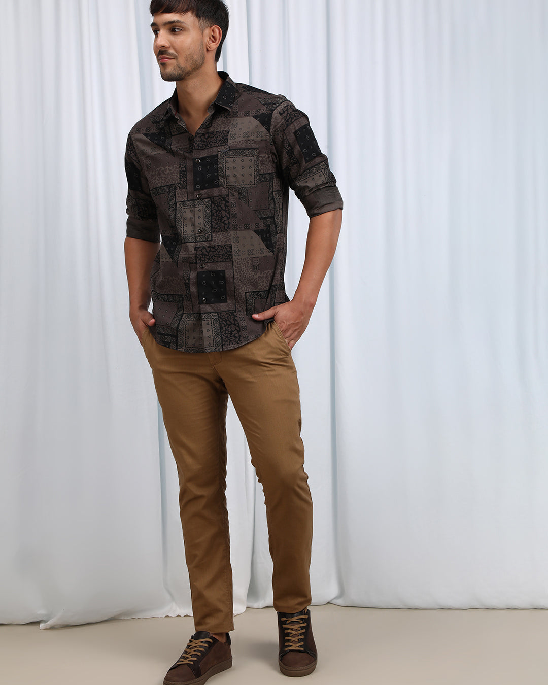 Man wearing a brown brown printed full sleeve casual 100% cotton shirt with casual styling on a gray background