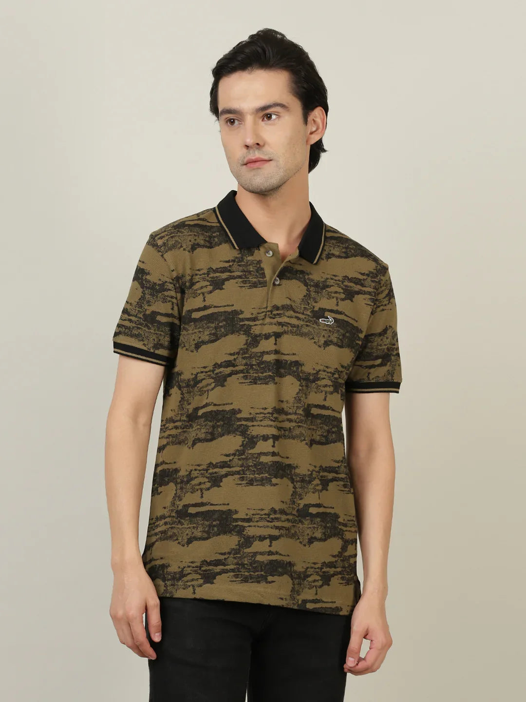 Man wearing a brown printed dark brown polo t shirt with casual styling on a gray background