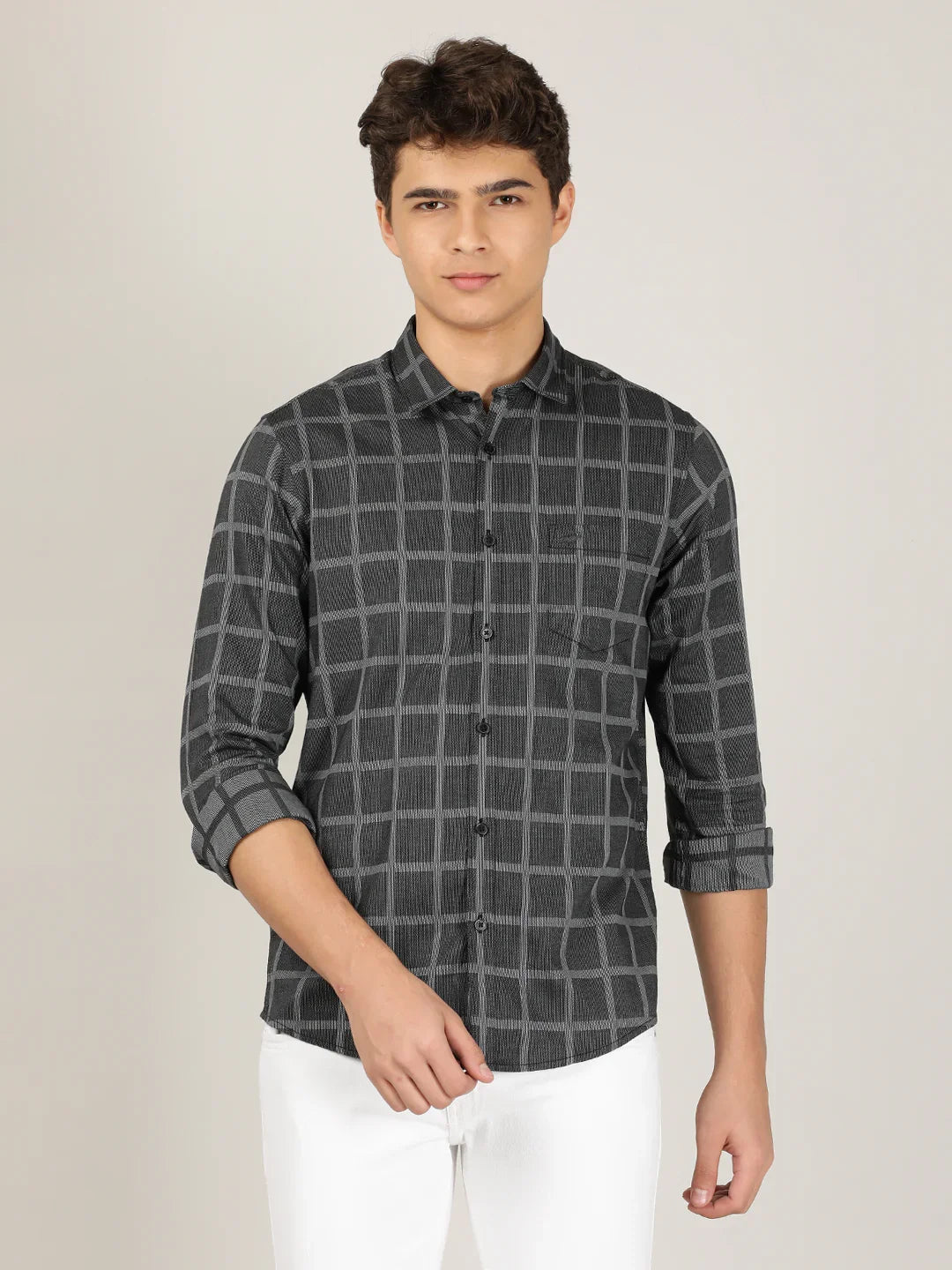 Man wearing a black black checked full sleeve 100% cotton casual shirt on a light gray background