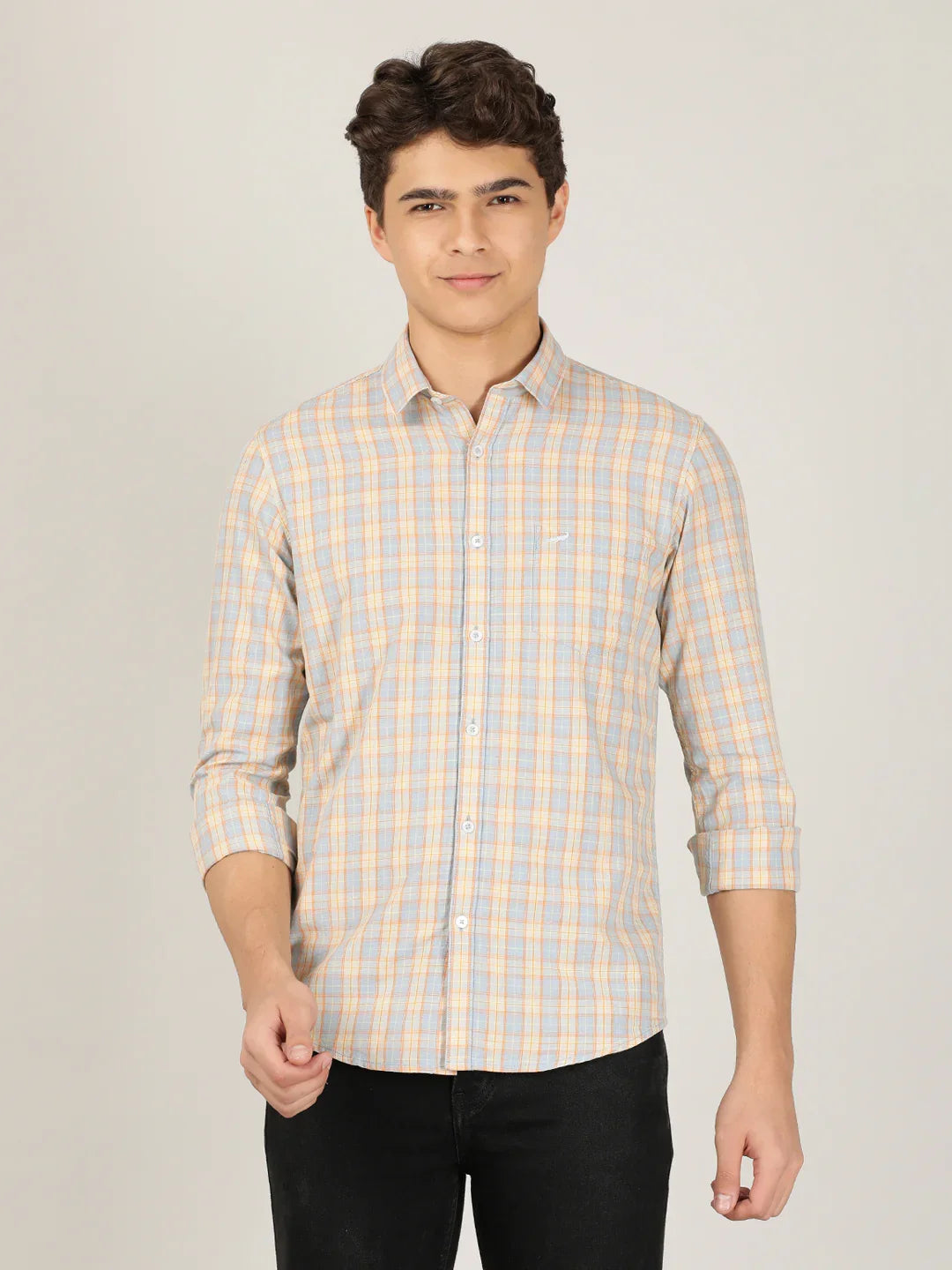 Man wearing a orange checked full sleeve 100% cotton casual shirt on a light gray background
