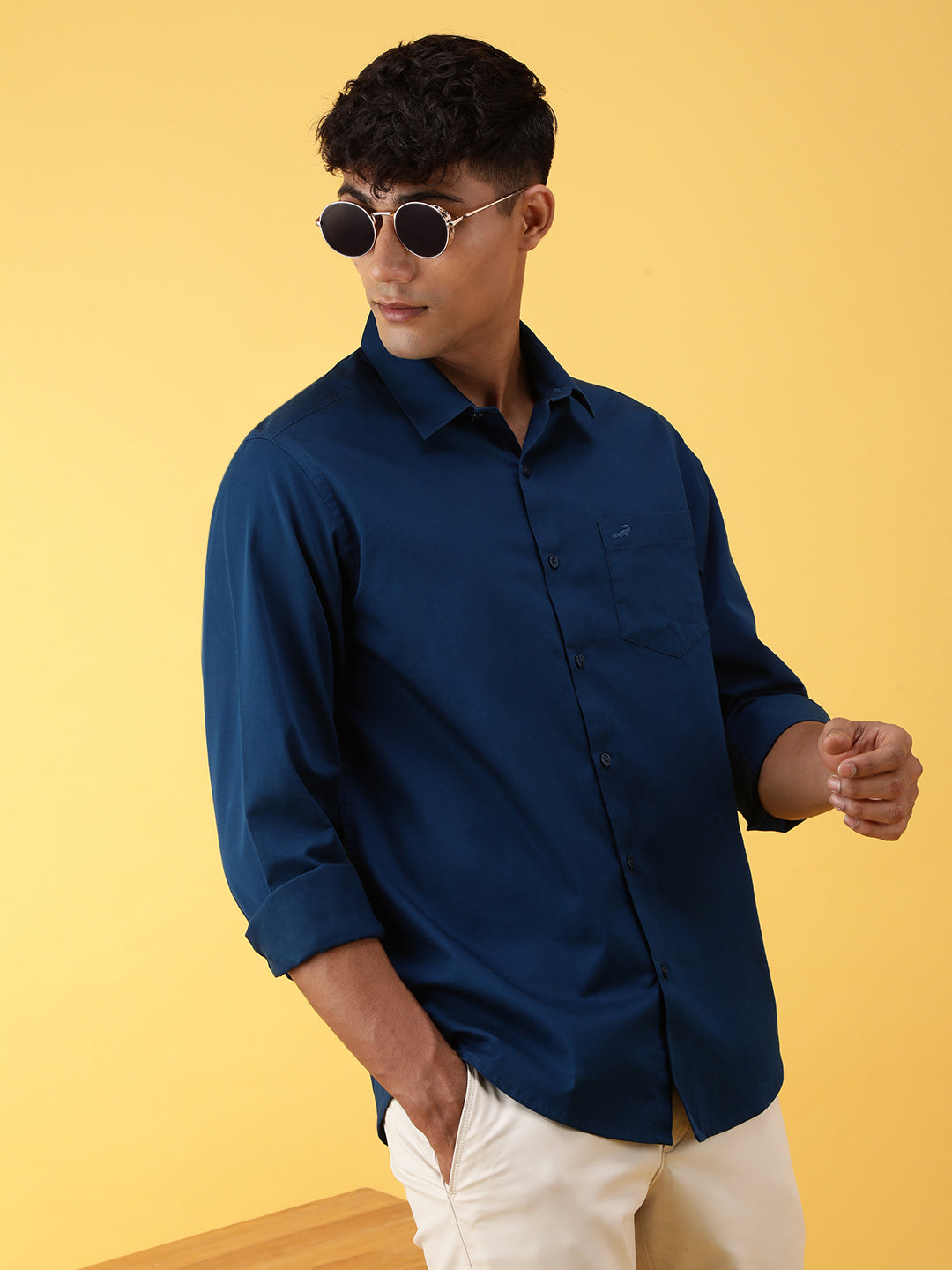 Man wearing a blue royal blue solid full sleeve 100% cotton casual shirt with casual styling on a gray background