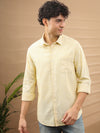 Man wearing a yellow linen blend stripe shirt yellow on a light gray background