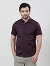 Man wearing a maroon printed half sleeve 100% cotton shirt with casual styling on a gray background