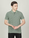 Man wearing a green dark green printed polo t shirt with casual styling on a gray background