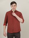 Man wearing a maroon checked full sleeve 100% cotton casual shirt with casual styling on a gray background