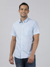 Man wearing a blue sky blue solid half sleeve 100% cotton shirt on a light gray background