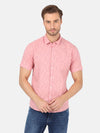 Man wearing a pink fadded pink printed half sleeve shirt on a light gray background