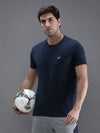 Man wearing a navy navy solid t shirt on a light gray background