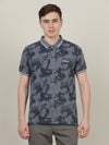 Man wearing a blue casual printed blue polo t shirt with casual styling on a gray background