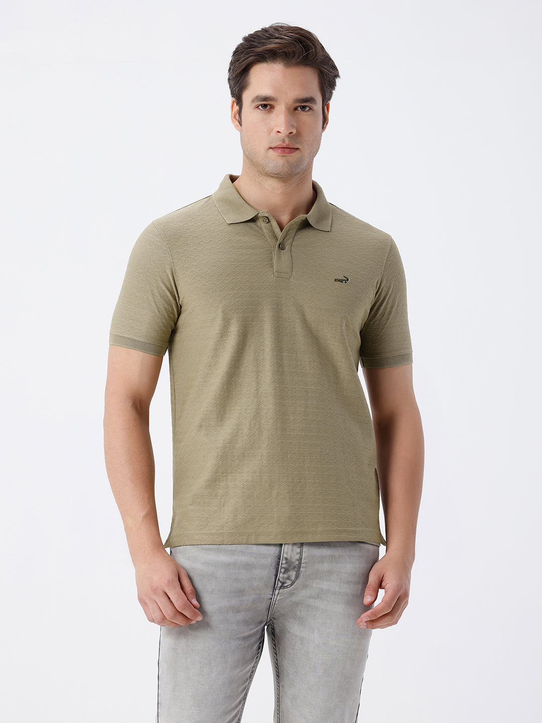 Man wearing a olive light olive structure comfort fit polo t shirt on a light gray background