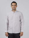 Man wearing a grey grey solid full sleeve linen shirt on a light gray background