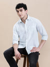 Man wearing a green crinkle textured pin stripe green shirt with casual styling on a gray background