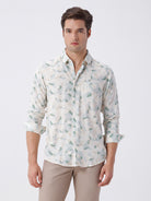 Man wearing a abstract leaf print linen shirt with casual styling on a gray background