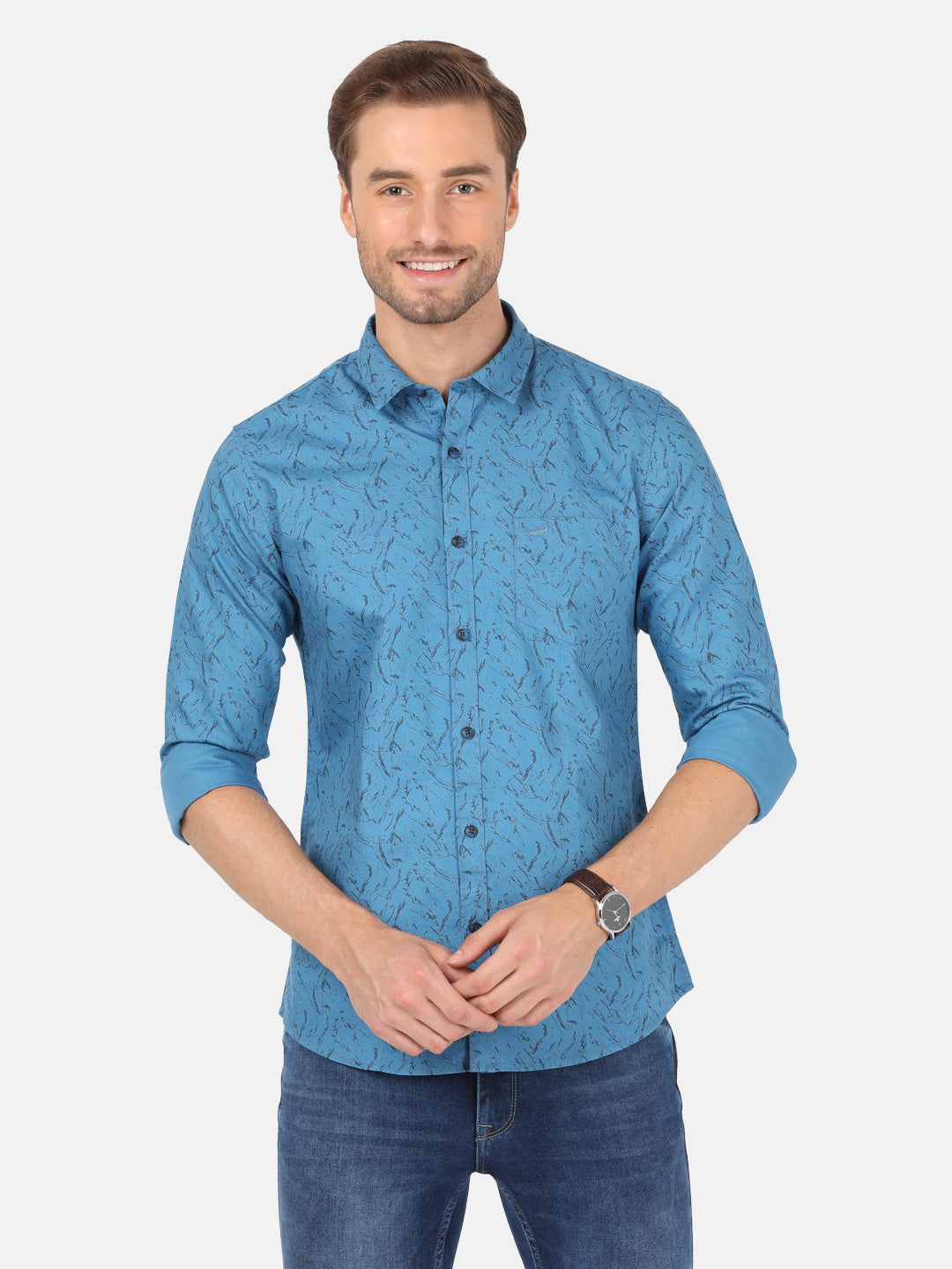 Man wearing a blue river blue printed full sleeve shirt on a light gray background