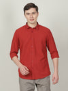 Man wearing a red rust red solid full sleeve 100% cotton shirt with casual styling on a gray background