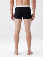 Person wearing black boxer briefs on a white background