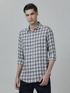 Man wearing a navy checked full sleeve 100% cotton navy casual shirt with casual styling on a gray background
