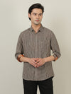 Man wearing a brown casual brown checked full sleeve 100% cotton shirt with casual styling on a gray background