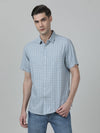 Man wearing a blue light blue checked half sleeve 100% cotton casual shirt with casual styling on a gray background