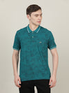 Man wearing a blue teal blue printed casual polo t shirt on a light gray background
