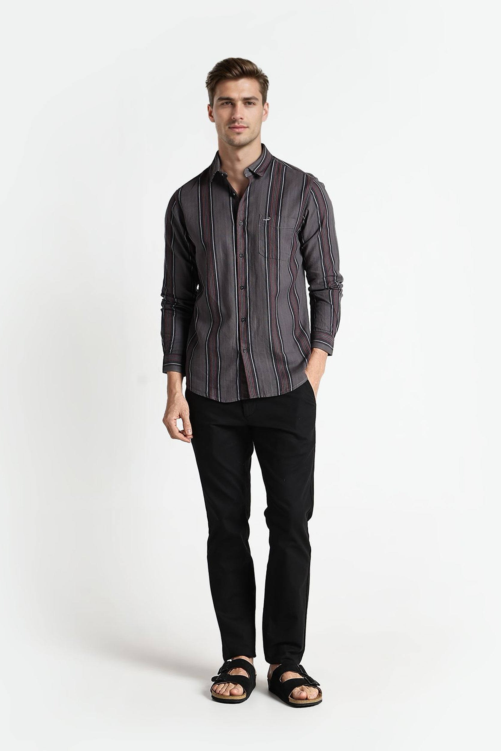 Man wearing a striped shirt and black pants on a white background