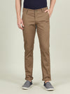 Man wearing a brown khaki brown solid casual slim fit trouser on a light gray background