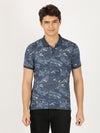 Man wearing a blue printed casual blue polo t shirt with casual styling on a gray background