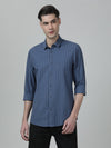 Man wearing a blue vintage blue striped full sleeve 100% cotton shirt with casual styling on a gray background