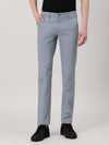 Man wearing a blue blue solid slim fit casual trouser on a light gray background
