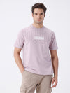 Man wearing a oversized placement print t shirt with casual styling on a gray background