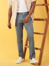 Man wearing a blue blue solid slim fit casual trouser with casual styling on a gray background