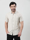 Man wearing a beige beige solid half sleeve linen shirt with casual styling on a gray background