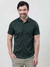 Man wearing a green green printed half sleeve 100% cotton casual shirt with casual styling on a gray background