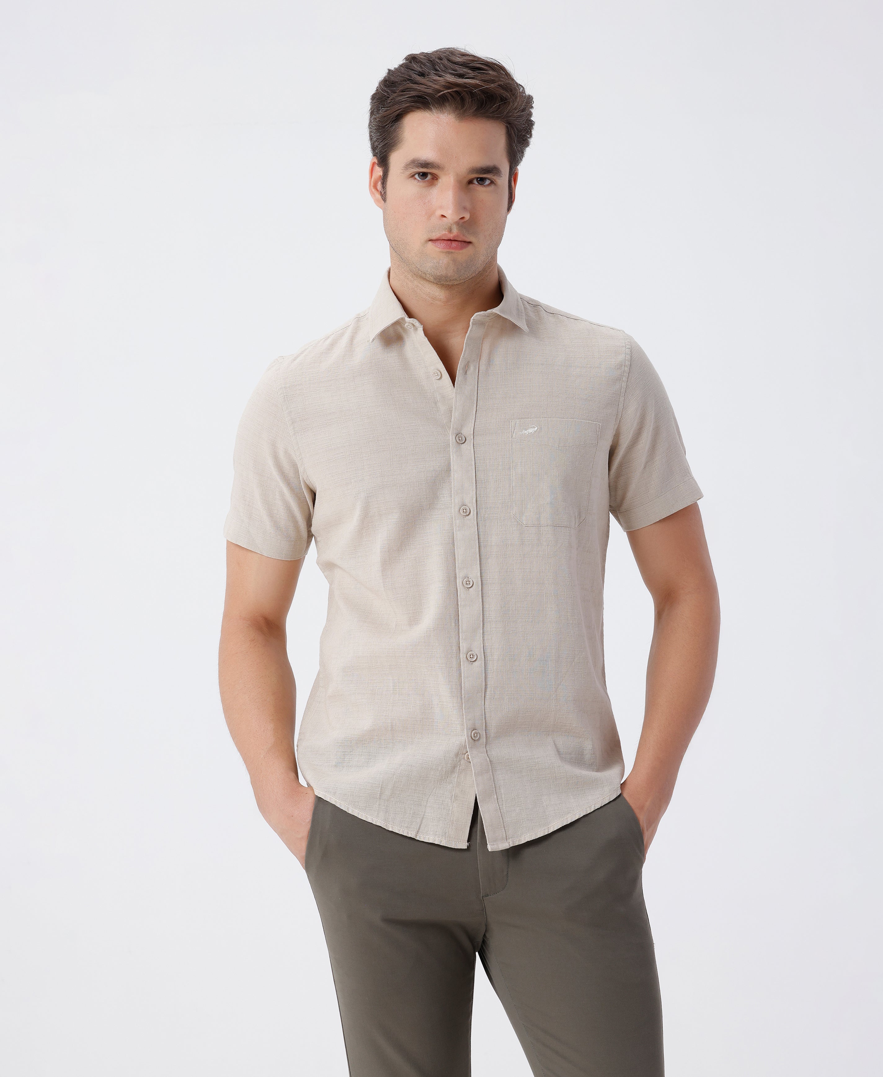 Man wearing a beige pure cotton textured shirt beige on a light gray background