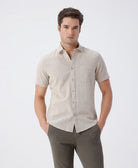 Man wearing a beige pure cotton textured shirt beige on a light gray background